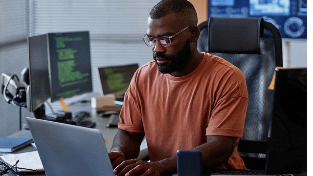 A person sitting at a desk in front of a laptop. Tableau vs Power BI Comparison